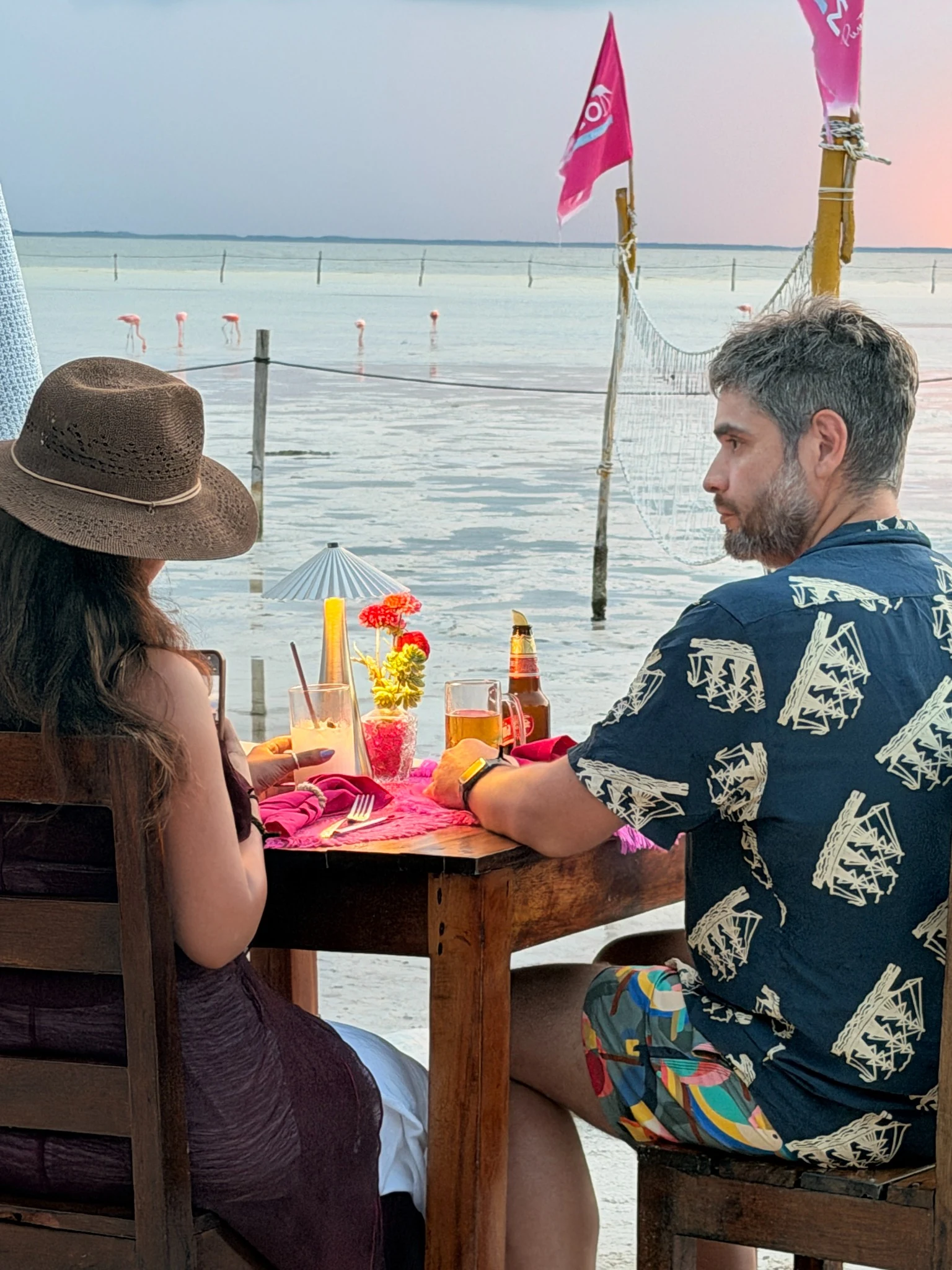 Pareja frente a flamencos en Holbox Mágico